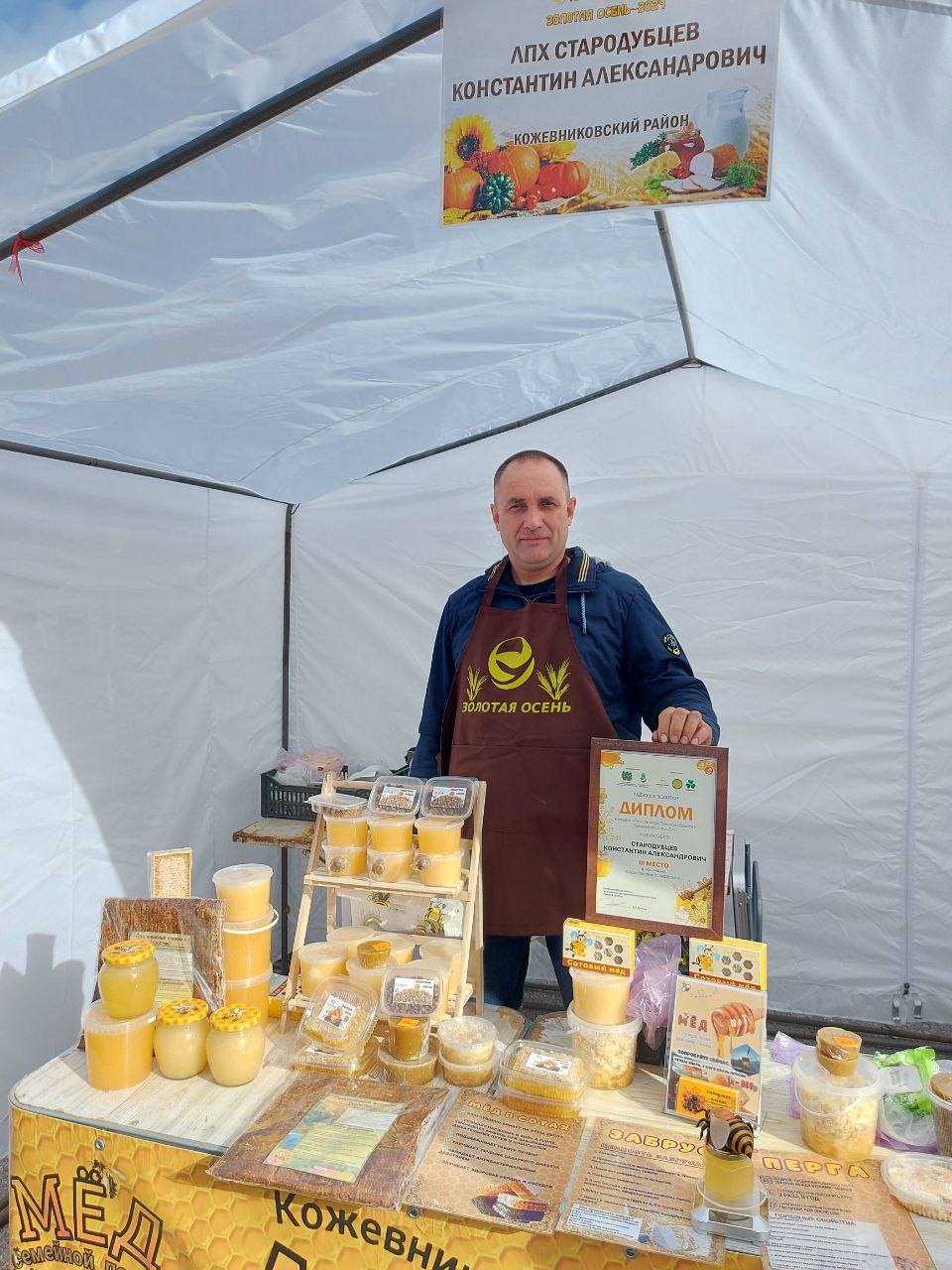 Мужчина за столом с продукцией на ярмарке